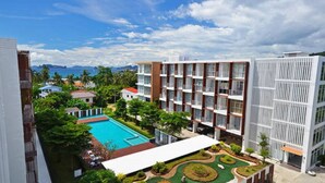 Un hotel moderno con piscina, jardines exuberantes y vistas al mar.