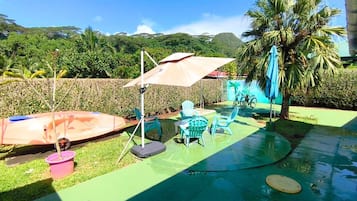 Un espace extérieur doté d’une piscine, de chaises et de parasols.