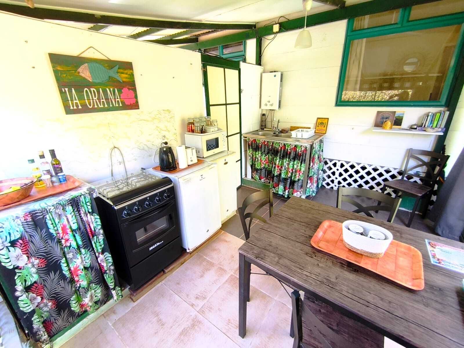 A compact kitchen with a stove, microwave, and a small dining area with a table and chairs.
