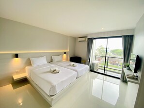 A modern hotel room with two beds, a balcony with a view, and a flat-screen TV on a stand. - Le Park Hotel (Thung Song)