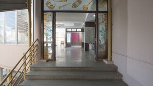 A staircase leading to a room with a 'Welcome' sign, a chair, and a water dispenser. - Hotel Sownthariyam (Palani)