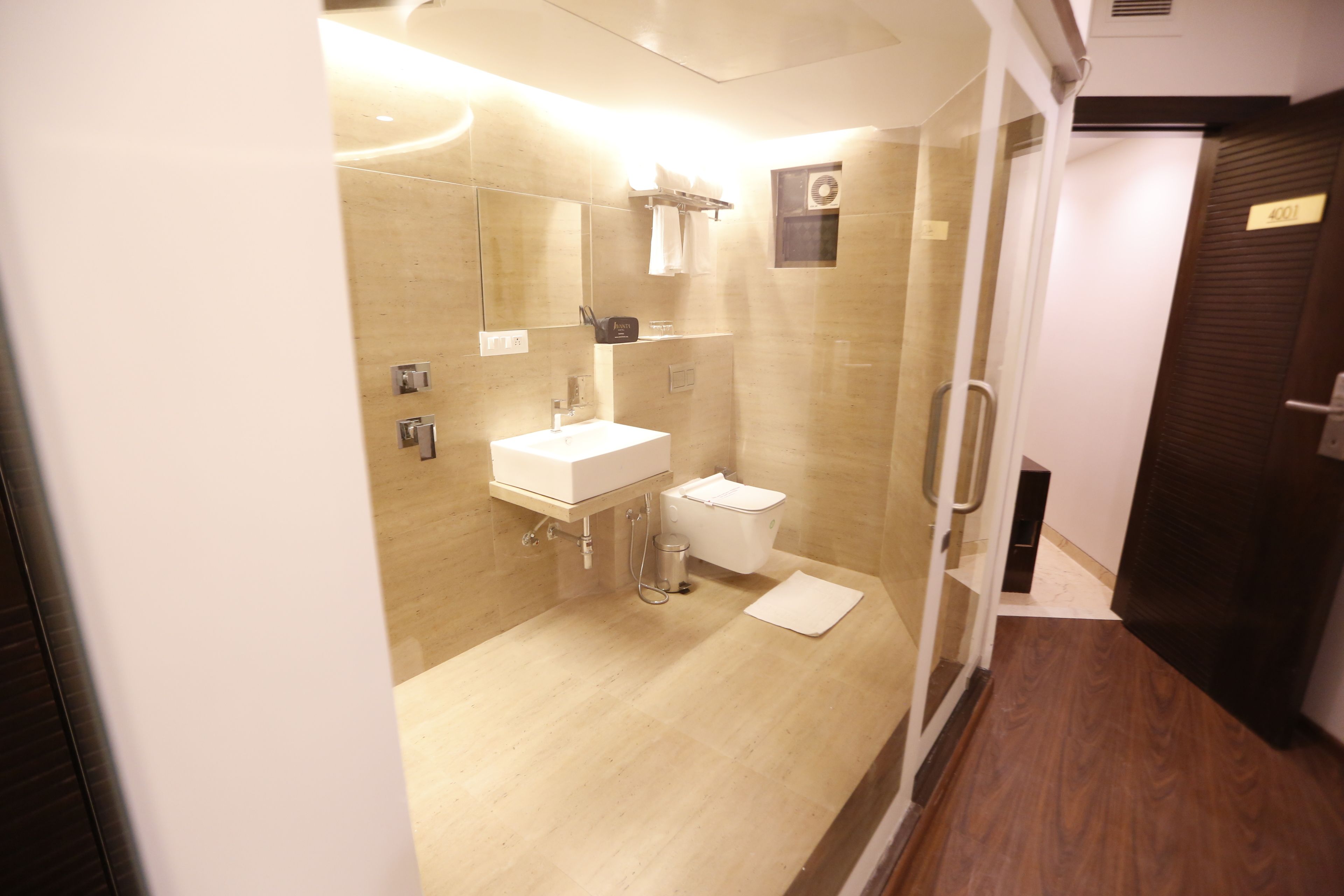 A modern bathroom with a glass shower enclosure, a sink, and a toilet.