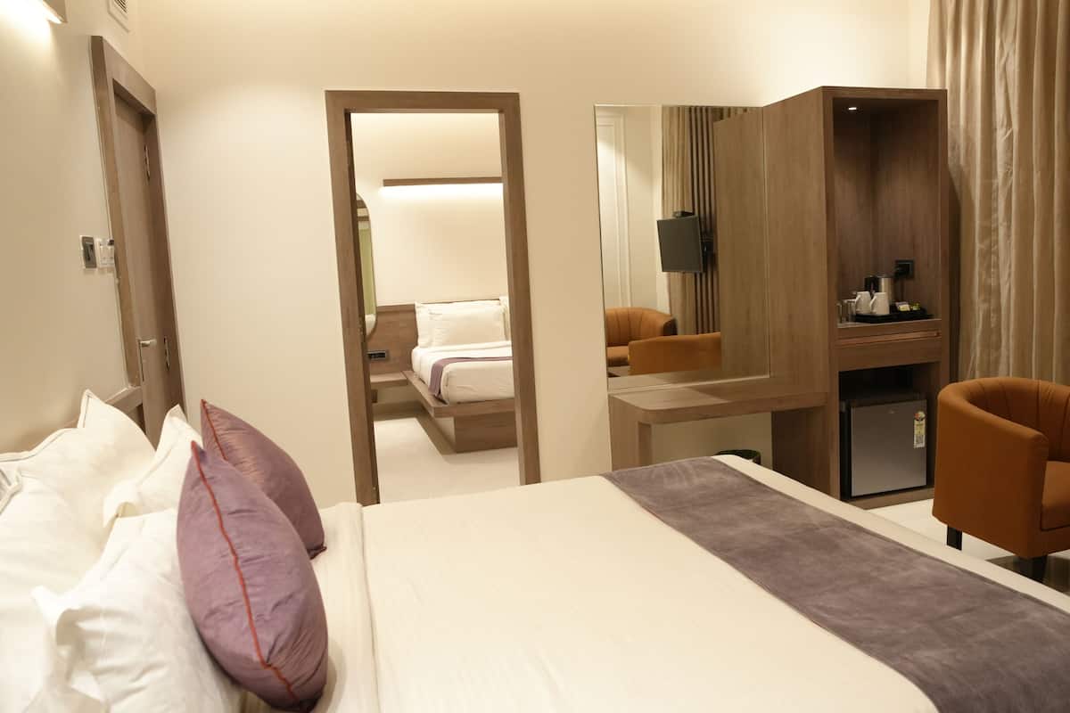Ein Hotelzimmer mit Bett, Schreibtisch, Stuhl und Spiegel.