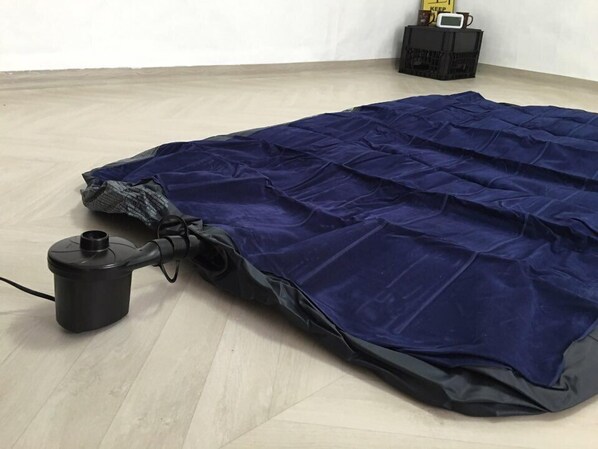 A blue mattress with a pump and a bag on a wooden floor. - MK guest house - Hostel (Seoul)