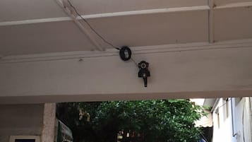 A ceiling with a security camera and a power cable.
