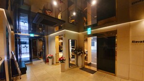 A hotel lobby with a modern design, featuring a reception desk, a staircase, and a parking area. - Hotel Star Premier Yeoksam (Seoul)