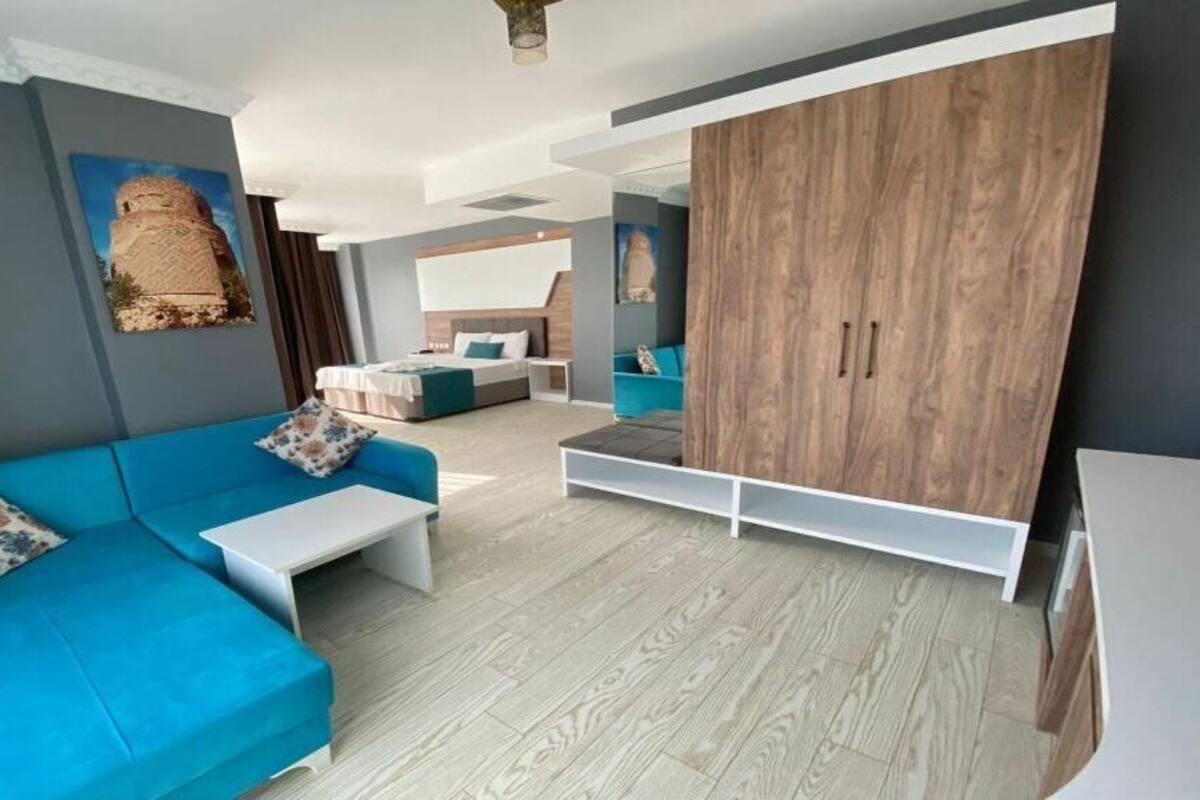 Una sala moderna con un sofá azul, una mesa de centro blanca y un armario de madera.