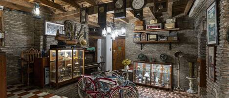 Quarto antigo com vigas de madeira, soalho xadrez e bicicletas antigas.
