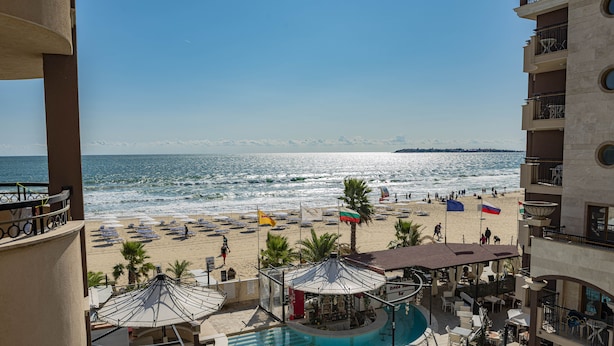 Zona de piscina con vista a la playa y al océano.