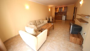 A living room with a sofa, coffee table, and TV stand. - Menada Sea Regal Apartments (Sunny Beach)