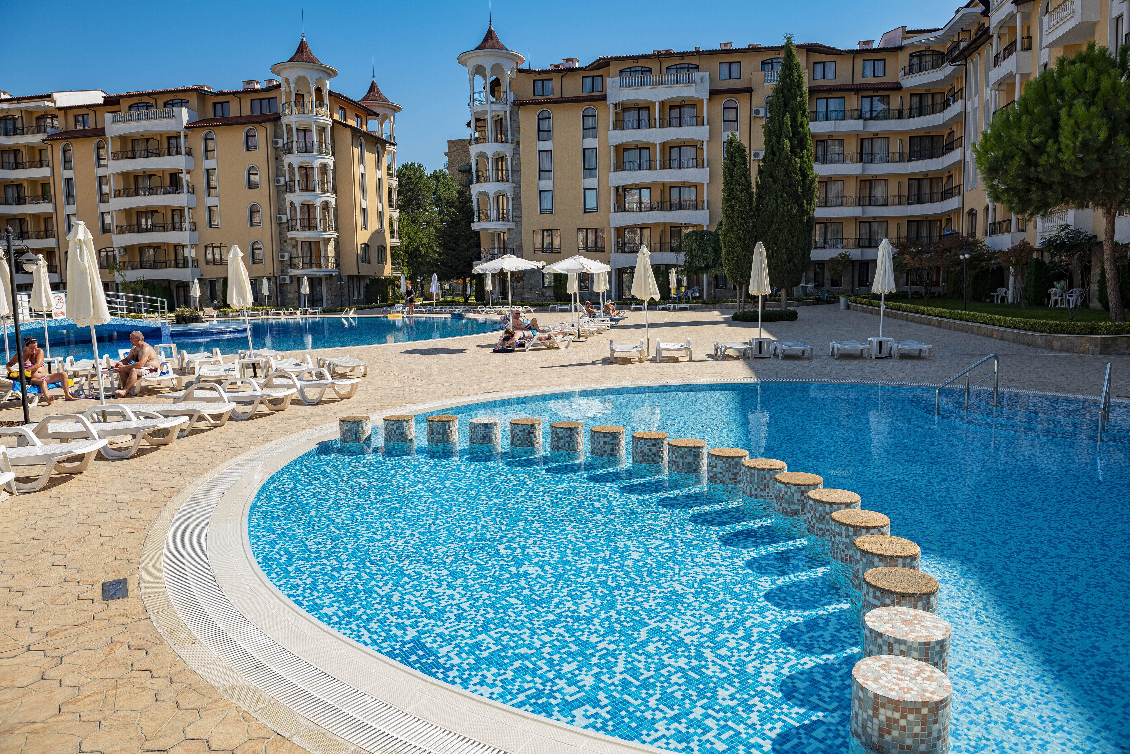 Una piscina al aire libre de temporada, sombrillas