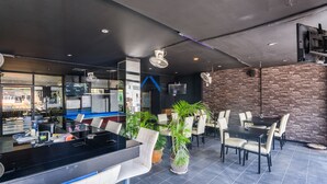Un restaurante moderno con mostrador, zona de comedor y pared de ladrillo.