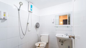 Un baño con inodoro, lavamanos, bidé y espejo.