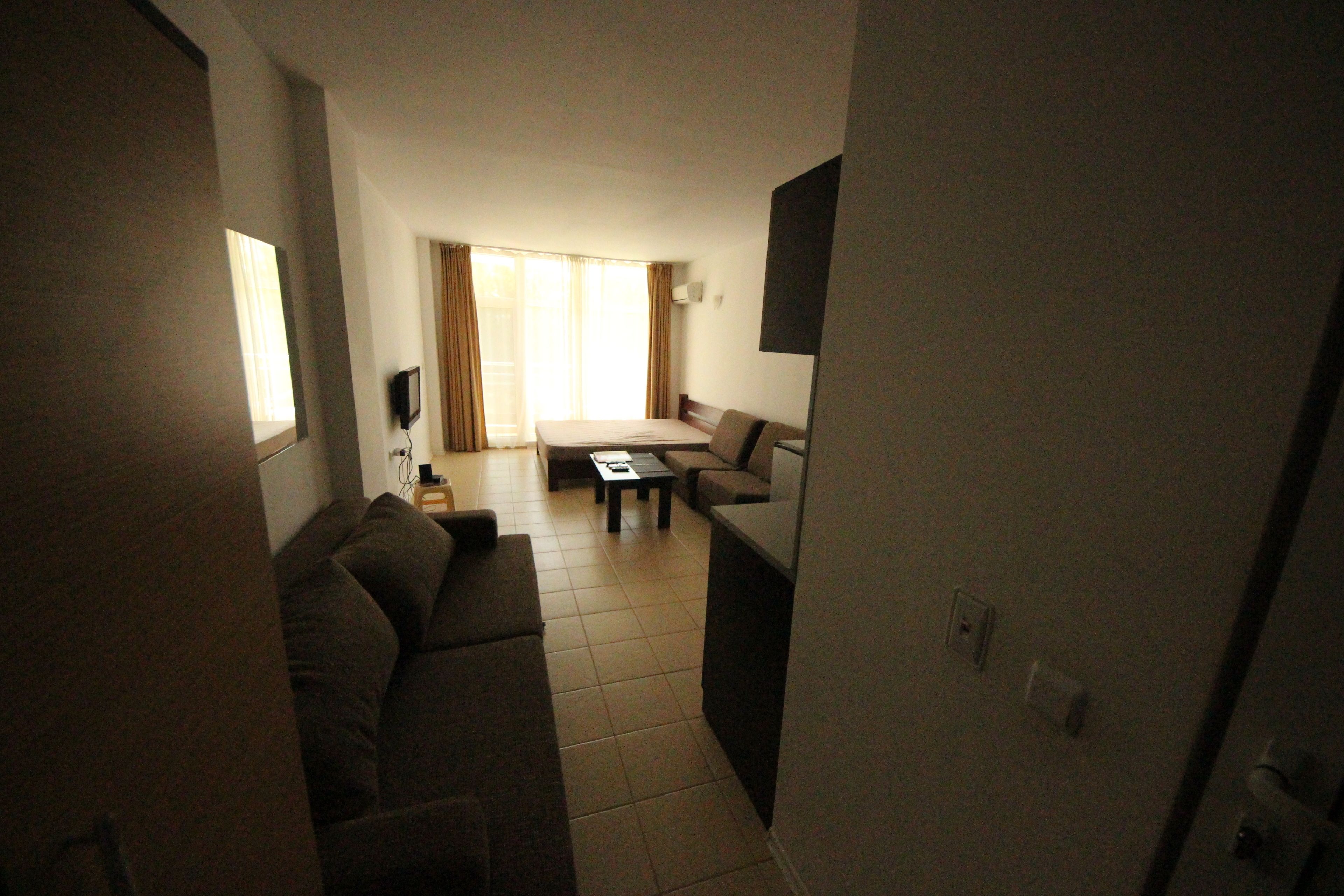 A compact living space with a sofa, a small table, and a TV.