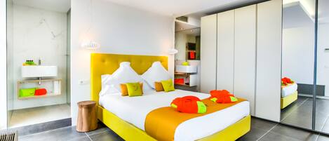 Ein modernes Schlafzimmer mit einem leuchtend gelben Bett, weißer Bettwäsche und einem großen Spiegel.