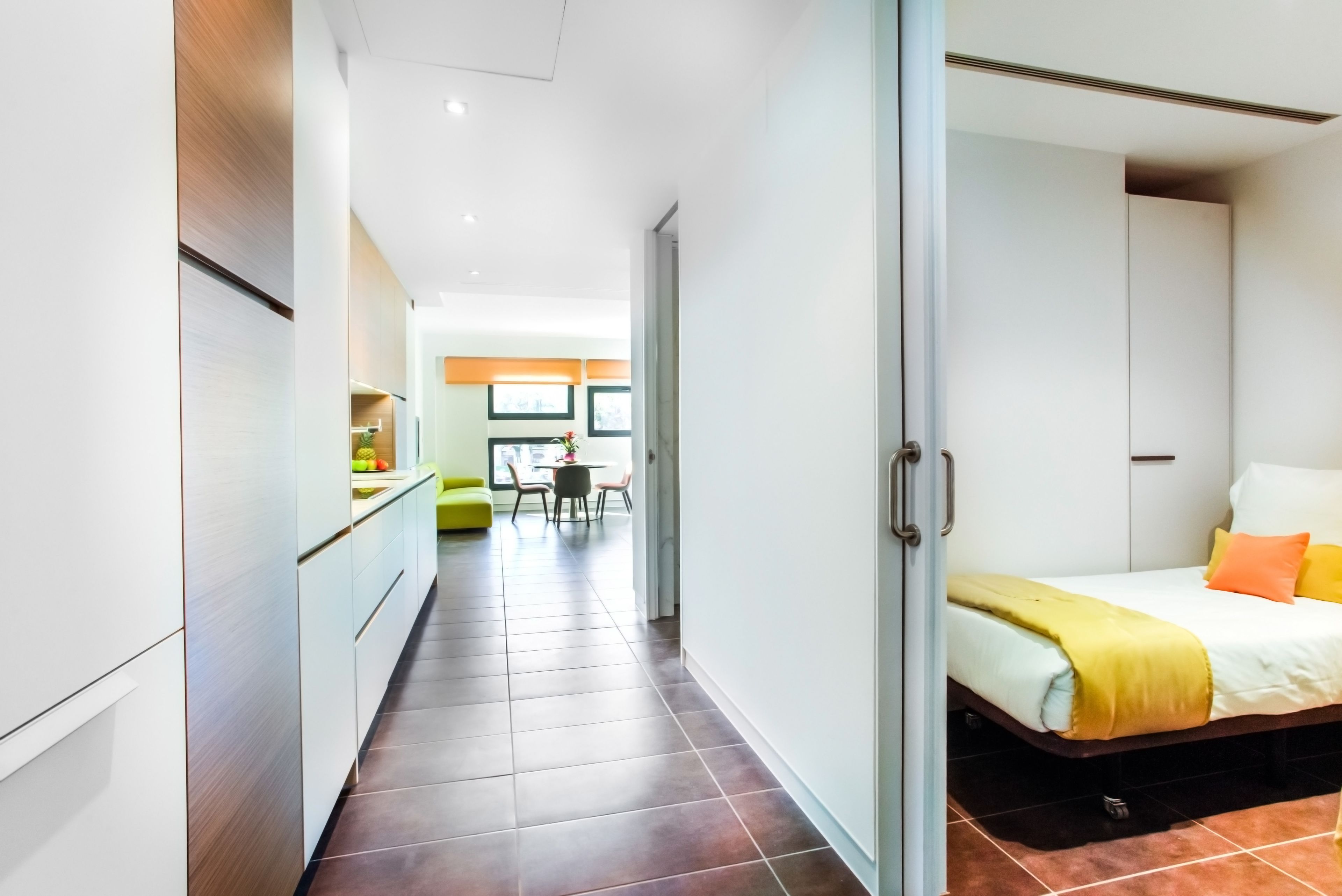 Una habitación de hotel moderna con cama, escritorio y kitchenette.