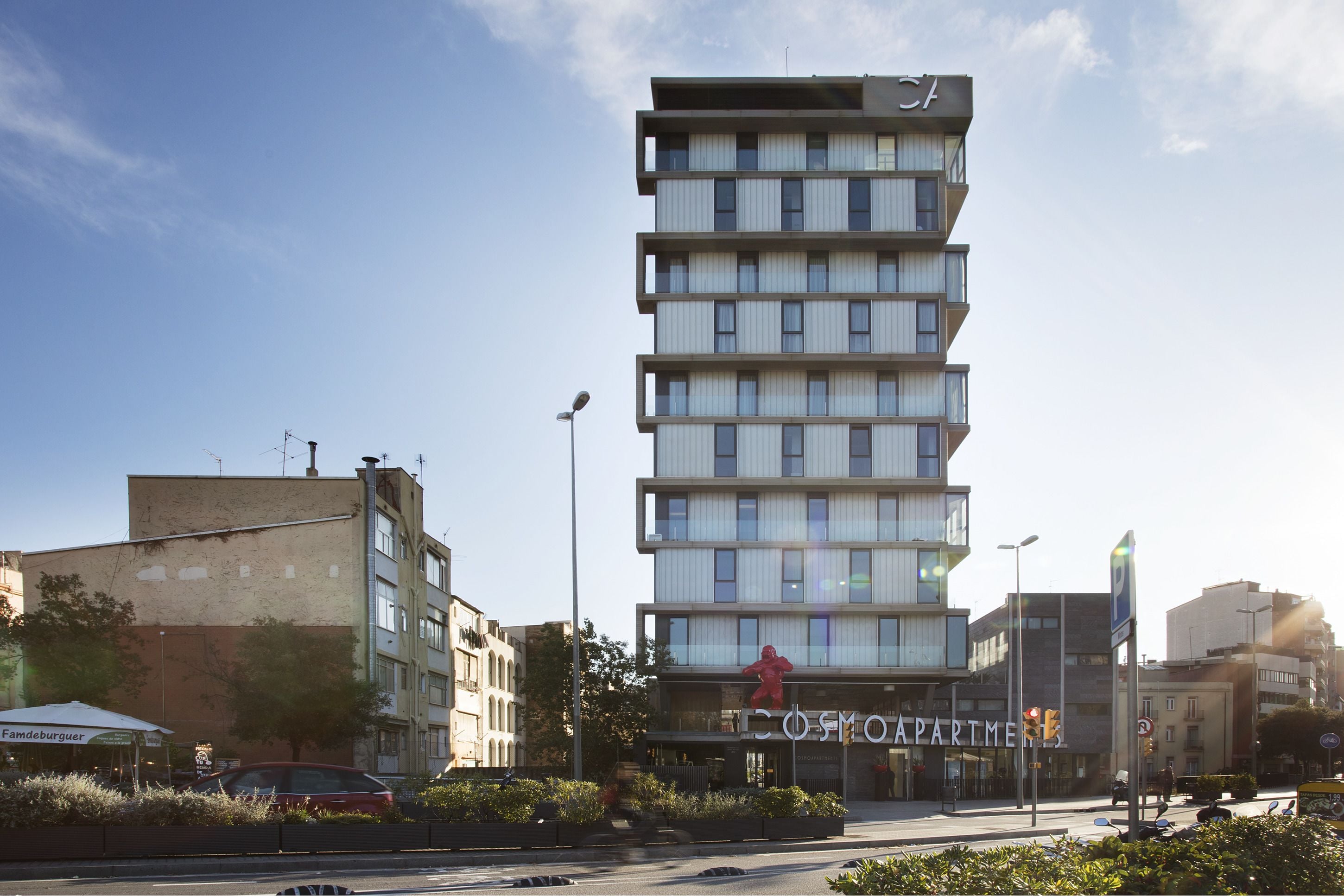 A multi-story building with a sign for 'Cosmo Apartman'.