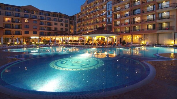 A hotel with a large central pool, multiple balconies, and outdoor seating areas. - Menada Diamant Residence Apartments (Sunny Beach)