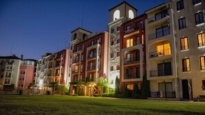 A multi-story residential building with balconies, a central courtyard, and a well-lit entrance. - Menada Rocamar Apartments (Tsarevo)
