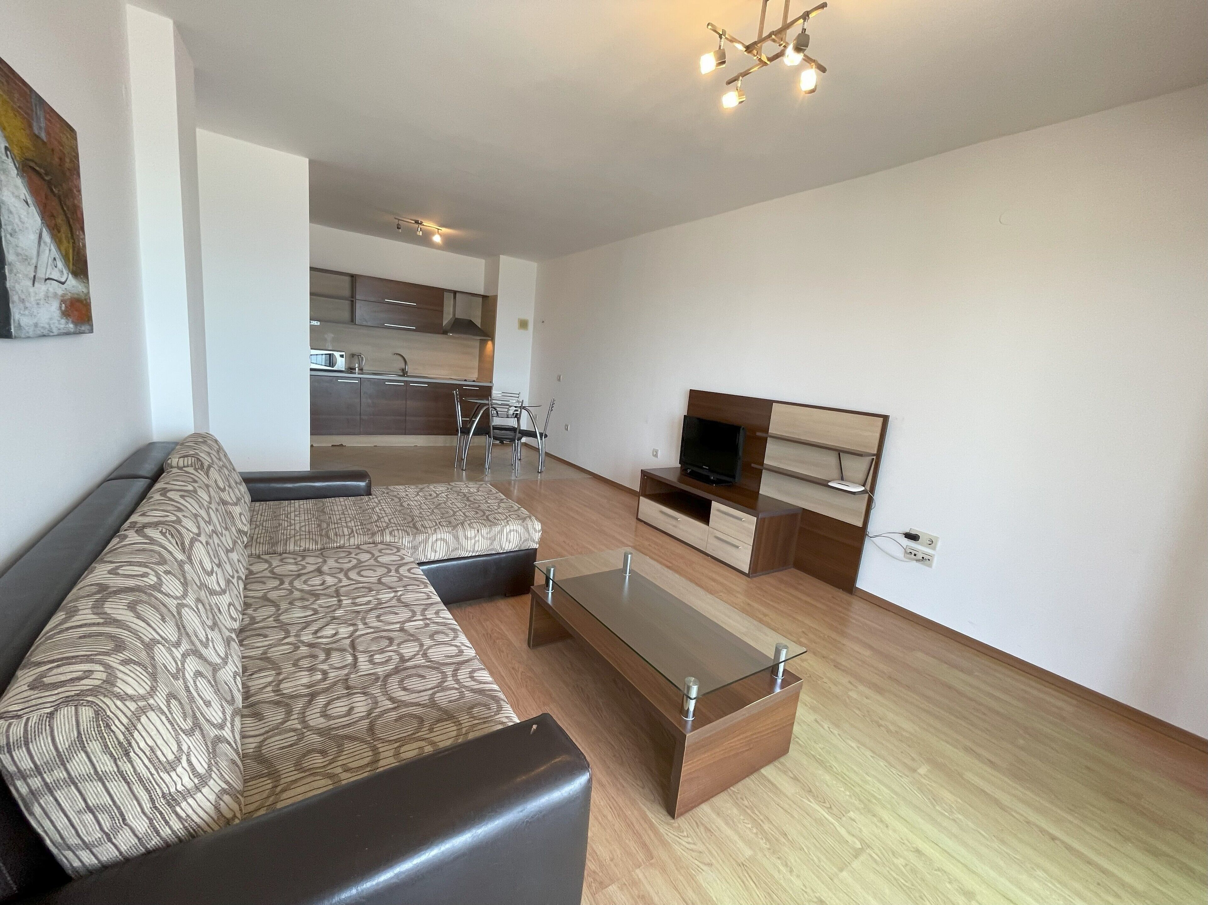 A modern living room with a sofa, a coffee table, and a TV stand.