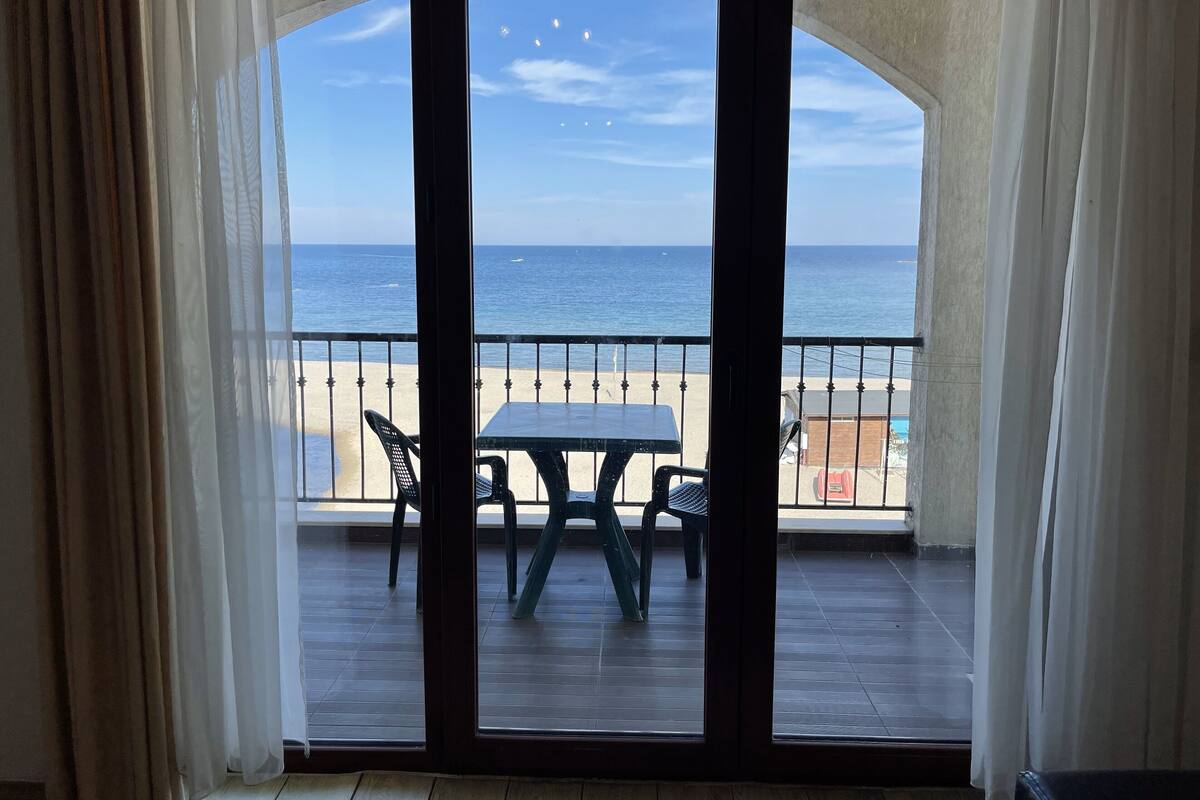 Een balkon met uitzicht op het strand en de oceaan.