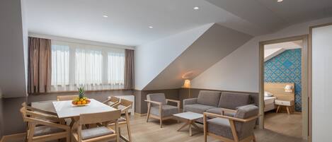 Un espacio habitable moderno y abierto con una mesa de comedor, sofás y una lámpara.