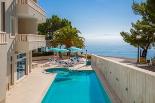 Una piscina al aire libre de temporada, sombrillas