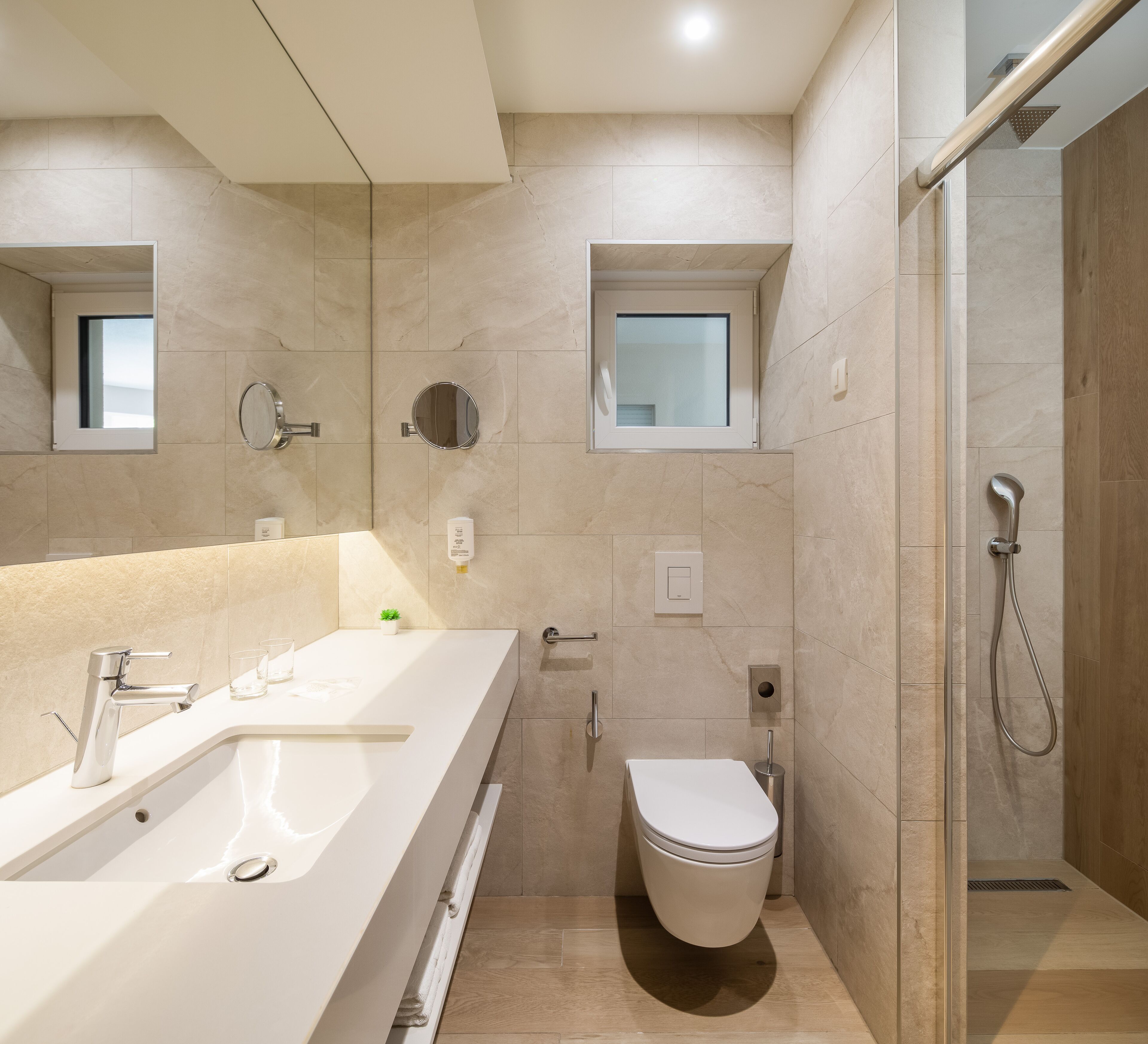 Ein modernes Badezimmer mit einem großen Waschbecken, einer Toilette und einer Duschkabine.