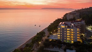 Un hotel sulla costa con vista sul mare e sul tramonto.