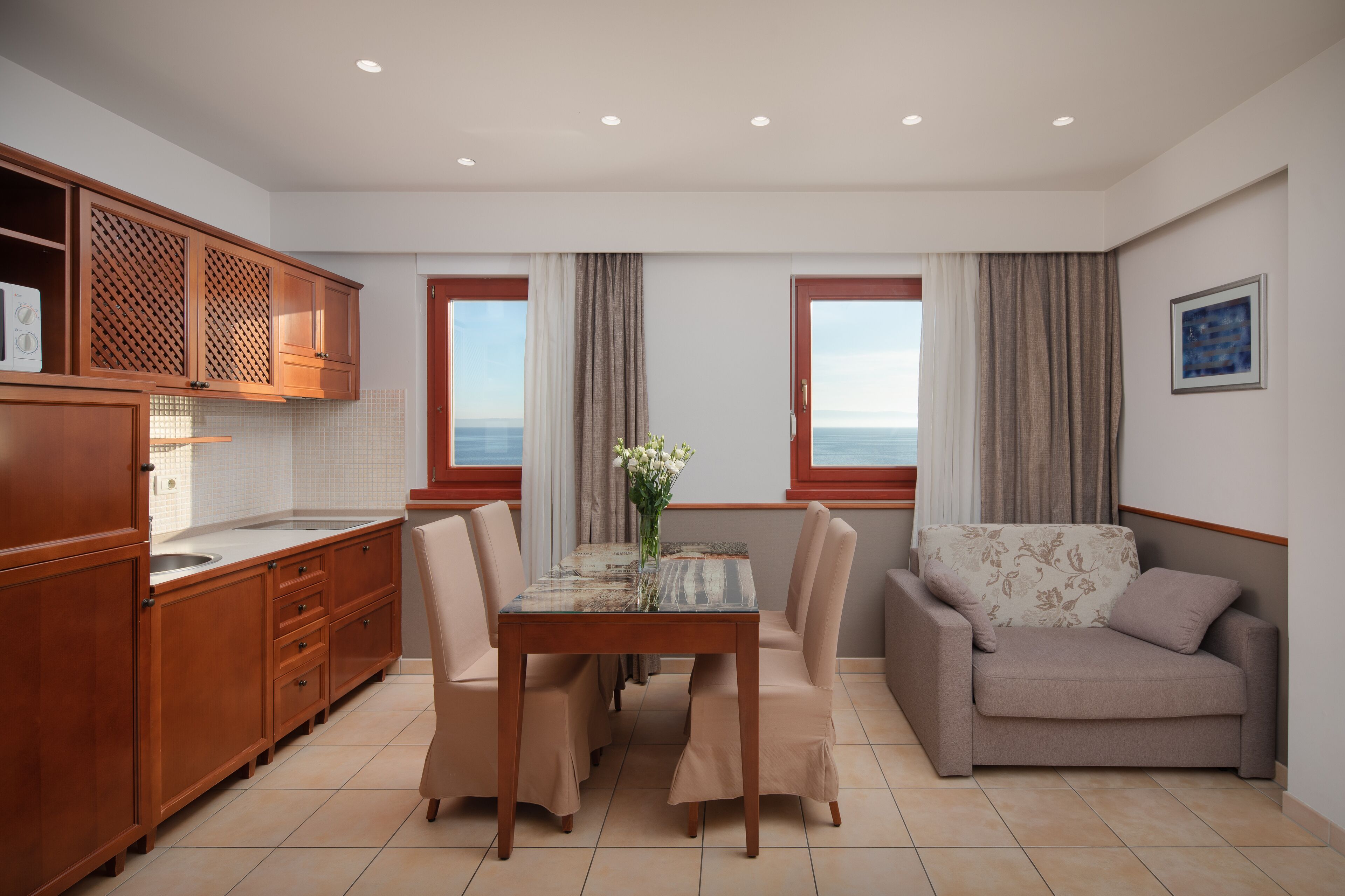 Une cuisine moderne avec des meubles en bois, une table à manger avec des chaises et un canapé.