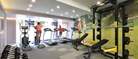 A gym with treadmills, dumbbells, and weightlifting equipment.