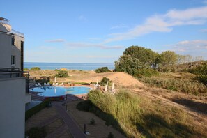 A modern building with a swimming pool and a view of the sea.