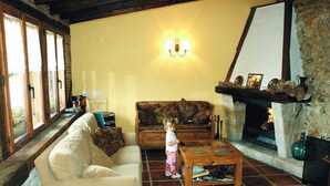 A cozy living room with a fireplace, a sofa, a coffee table, and a child. - Aristieta (Ajangiz)
