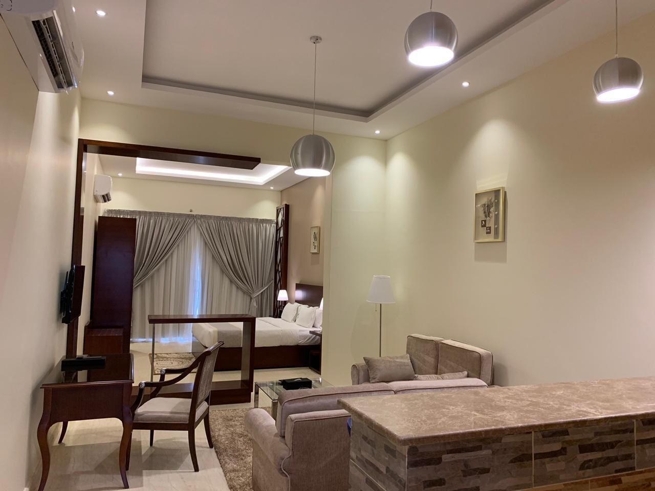 Ein modernes Hotelzimmer mit Bett, Schreibtisch, Sofa und Fernseher.