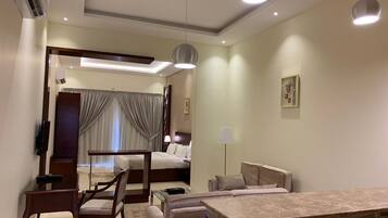 Ein modernes Hotelzimmer mit Bett, Schreibtisch, Sofa und Fernseher.