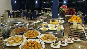 A buffet with various food items and a dessert section. - Hotel & Resort Golden Marina Yanbu  فندق ومنتجع جولدن مارينا ينبع إدارة وتشغيل شركة منتج ع المرسى الذهبي (Yanbu)