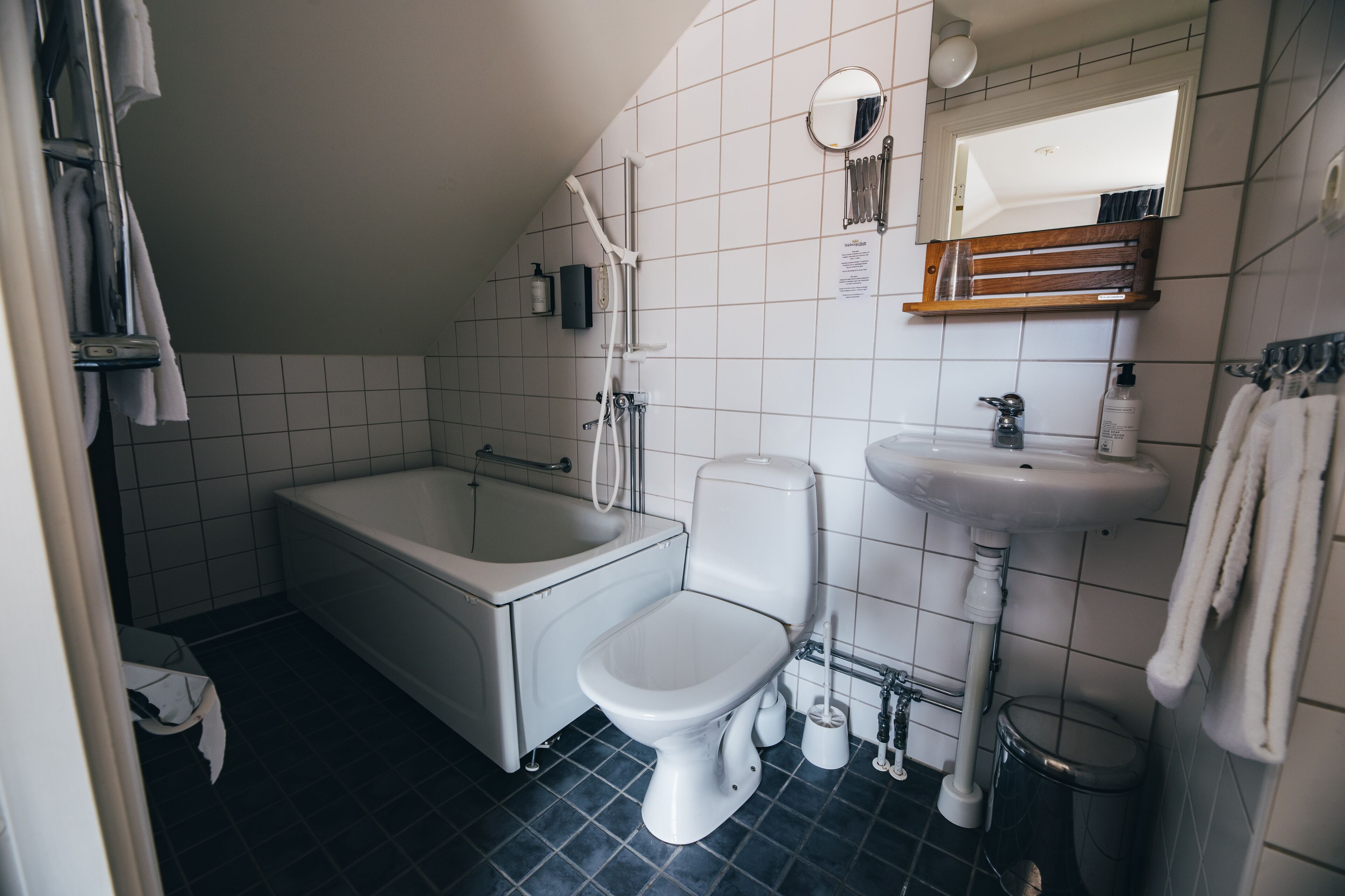 Une salle de bain avec une baignoire, des toilettes, un lavabo et un miroir.