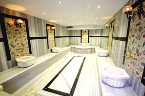 Une salle de bain moderne avec un grand miroir, une baignoire et des toilettes.