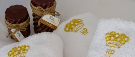 Three jars of dark red wax with a tag, and two towels with embroidered crowns and the letters "HP".