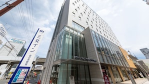 A modern building with a glass facade and signage for 'MIND HOUSE' and 'MANGINYORIKU HOTEL'. - Sanco Inn Yokkaichi Ekimae (Yokkaichi)