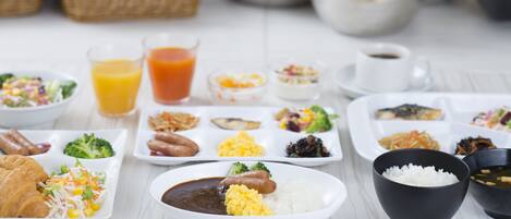 A variety of dishes including rice, beans, and vegetables on a white table.