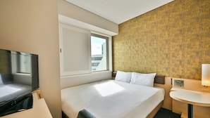 A hotel room with a bed, a television, a window, and a small desk with a lamp. - Sanco Inn Yokkaichi Ekimae (Yokkaichi)