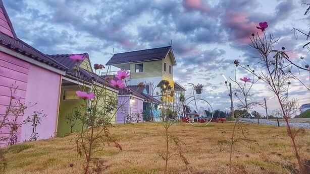 A residential area with houses, a grassy yard, and a cloudy sky. - Lovely Farm (Khao Kho)