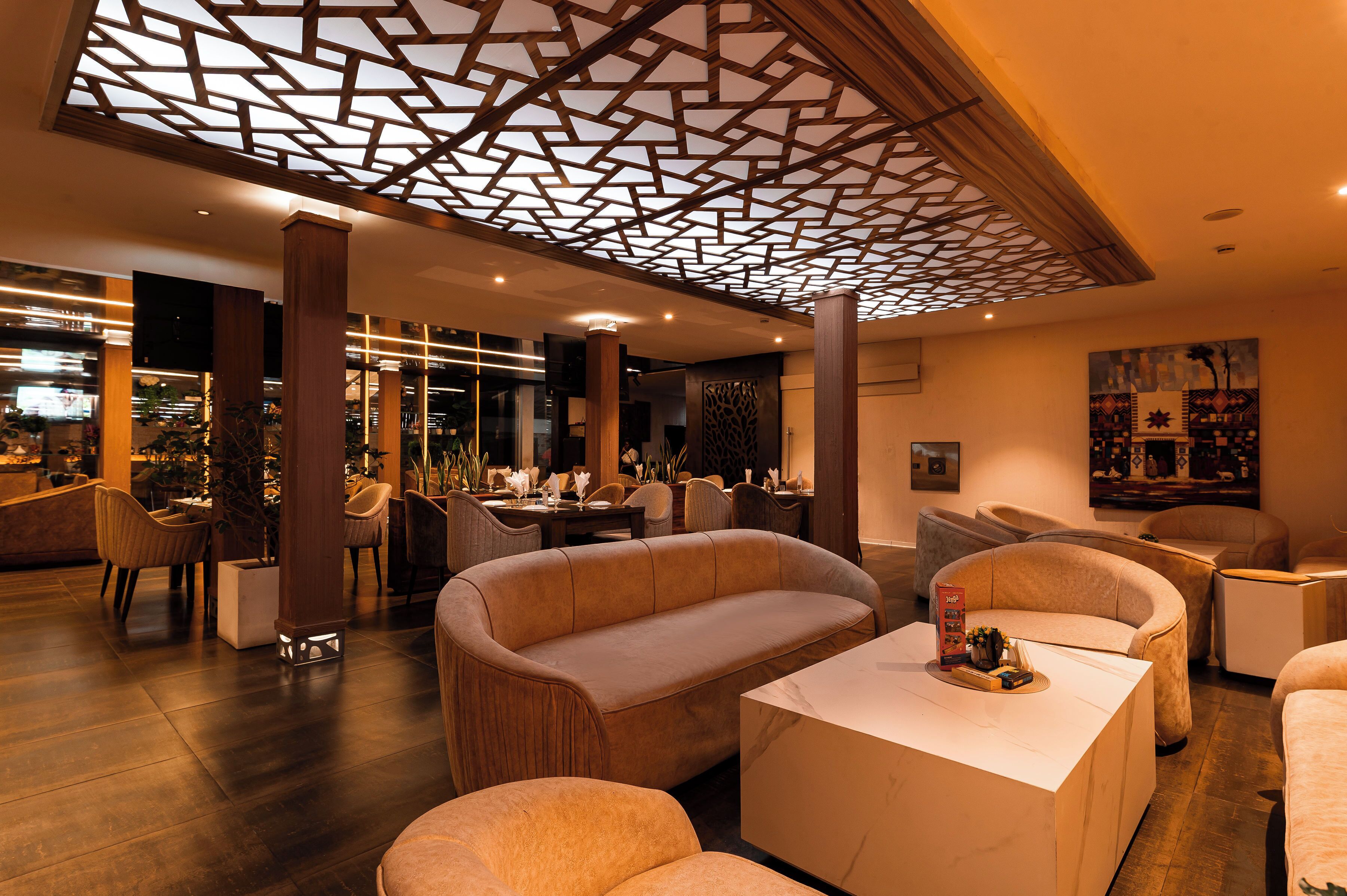A modern interior with a central seating area, a bar, and a dining space.