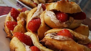 A plate of food with bread rolls filled with cream and strawberries. - Morada do Sol Guest House (Búzios)
