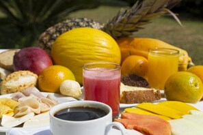 Ein reichhaltiges Frühstücksbuffet mit Früchten, Saft und Gebäck.