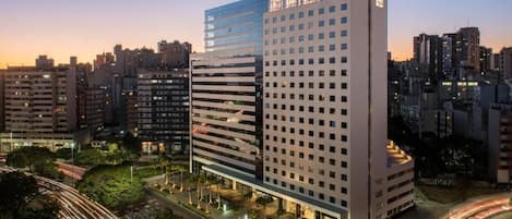Un hotel moderno de gran altura con varias plantas y una fachada bien iluminada.