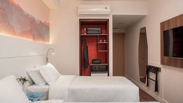 A hotel room with two beds, a wardrobe, a TV, and a painting on the wall.