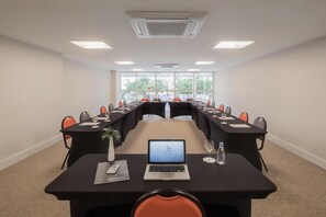 A conference room with a long table, chairs, laptops, and a view through large windows. - Intercity Porto Alegre Cidade Baixa (Porto Alegre)