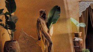 A room with a stone wall, a large potted plant, and a statue. - Riad Persephone (Marrakech)